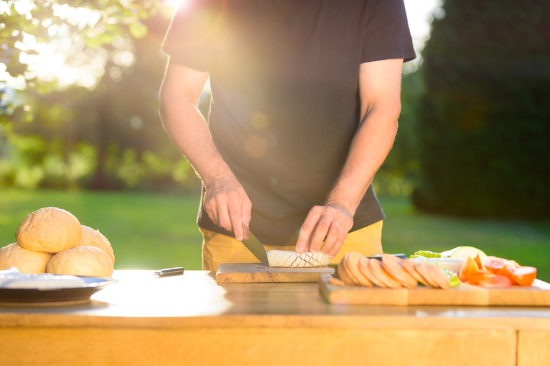 Man cutting food for summer garden party